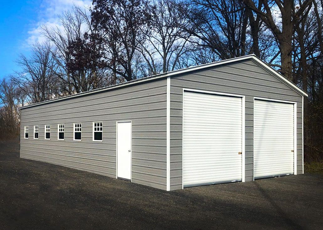 A gray steel garage with white doors and windows