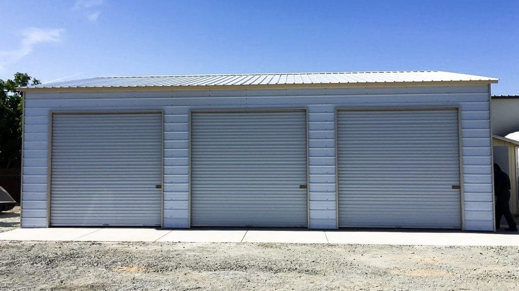 A white steel garage with three closed doors