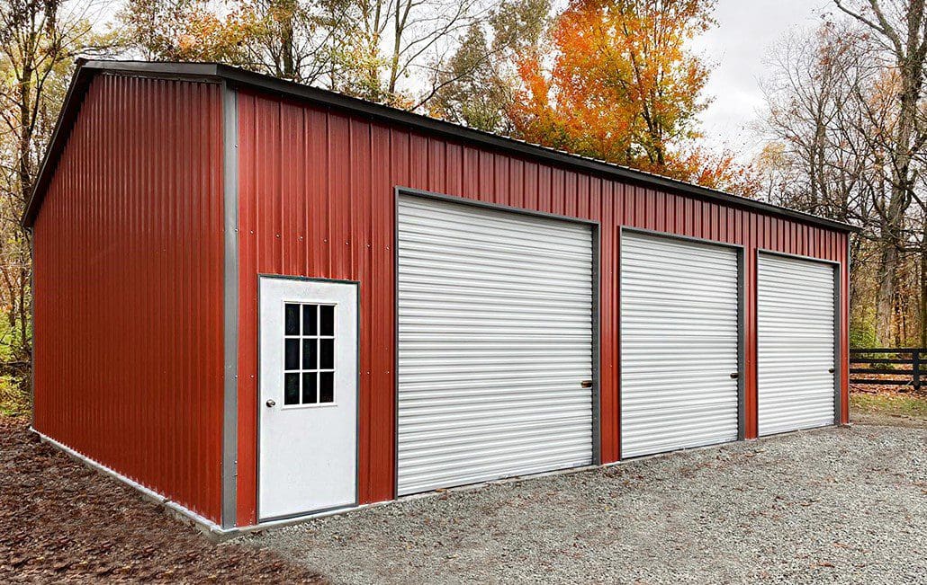 A large red steel garage with white doors for three vehicles