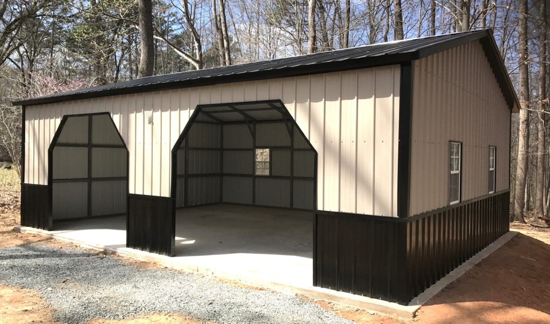 A metal house with two giant doors with trees all around